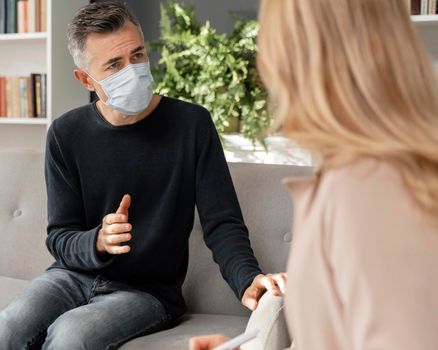 mid shot man talking therapist wearing mask