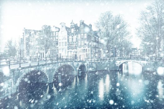 View of Amsterdam canal by night with snow, Netherlands