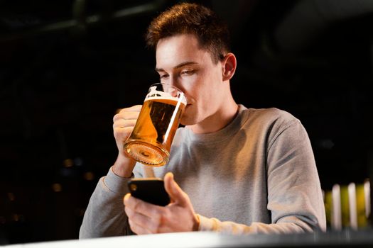 medium shot man with phone beer mug