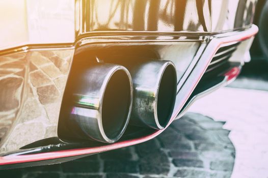 Close up of a car dual exhaust pipe in sunlight background