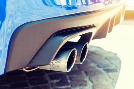 Close up of a car dual exhaust pipe in sunlight background