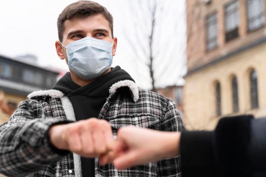 alternative greetings almost touching fist bumps man with mask