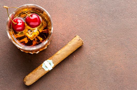 high angle whiskey rocks with cherries cigar with copy space