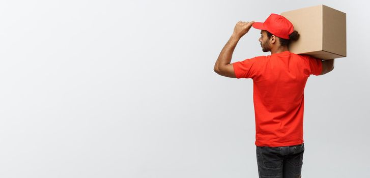 Delivery Concept - back view of Handsome African American delivery man with box package. Isolated on Grey studio Background. Copy Space