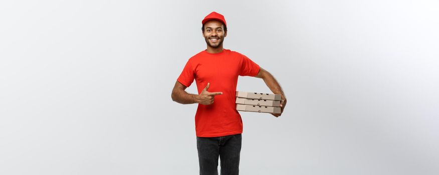 Delivery Concept - Portrait of Happy African American delivery man pointing hand to present a box package. Isolated on Grey studio Background. Copy Space