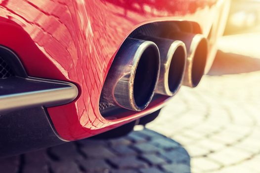 Close up of a car dual exhaust pipe in sunlight background