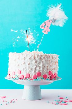 fourth birthday cake with burning sparkler white surface