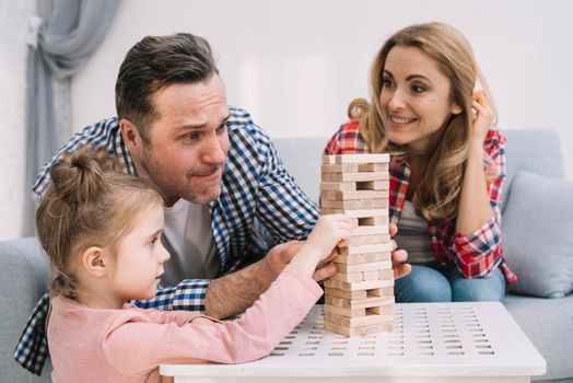 family playing with block wooden game table living room