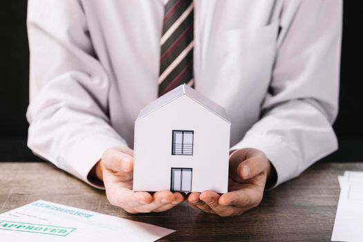 crop man holding paper house