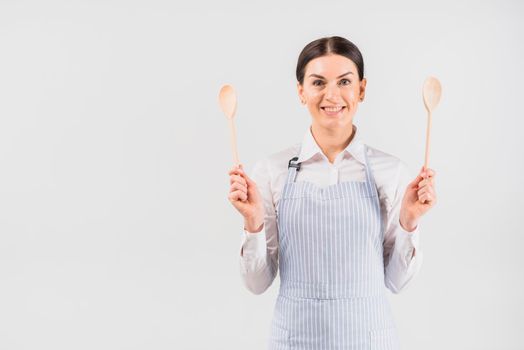 female apron smiling holding spoons