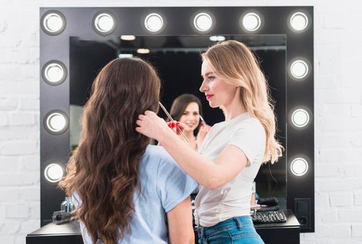 blonde doing eye makeup client with brush