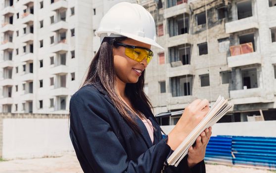 african american lady safety helmet with notepad near building construction