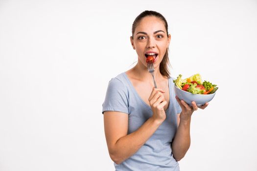 woman eating tomato with fork