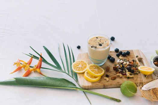 bird paradise flower smoothie with dryfruits citrus fruits white background