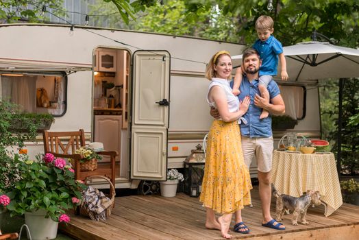 long shot family posing their caravan