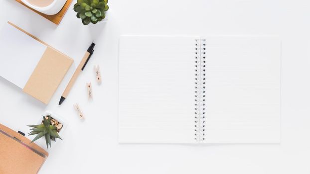 notepad near stationery flower pots white table