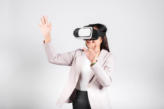 Smiling woman confidence excited wear VR headset device touching air during virtual reality experience isolated white background, Asian happy portrait female playing video game studio shot, copy space