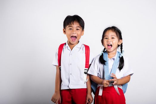 Two Asian student kid girl boy schoolchildren brother sister smile happy wear student thai uniform red pants skirt in studio shot isolated on white background, Portrait little children girl preschool