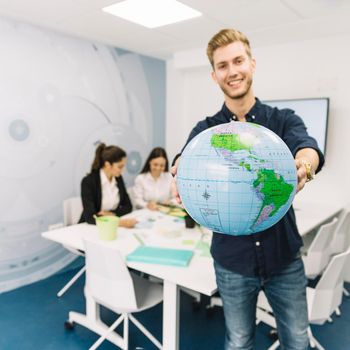 happy young businessman holding globe office