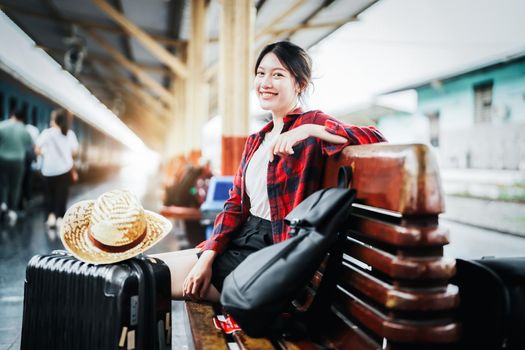 summer, relax, vacation, travel, portrait of cute Asian girl showing smile and waiting at the train station for a summer trip