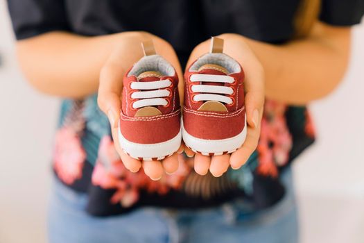 newborn concept with woman with little shoes hands