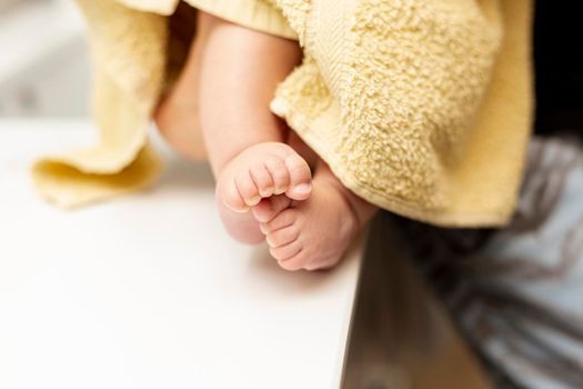 close up baby legs with yellow towel