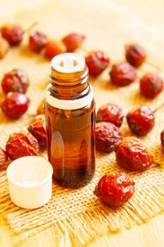 Rosehip seed essential oil in a small bottle. Selective focus.Na