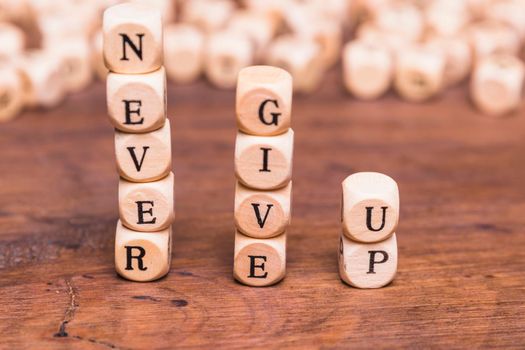 stacked wooden blocks with word never give up wooden desk