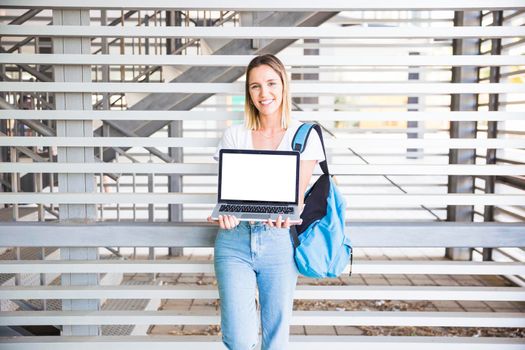 cheerful woman showing laptop camera