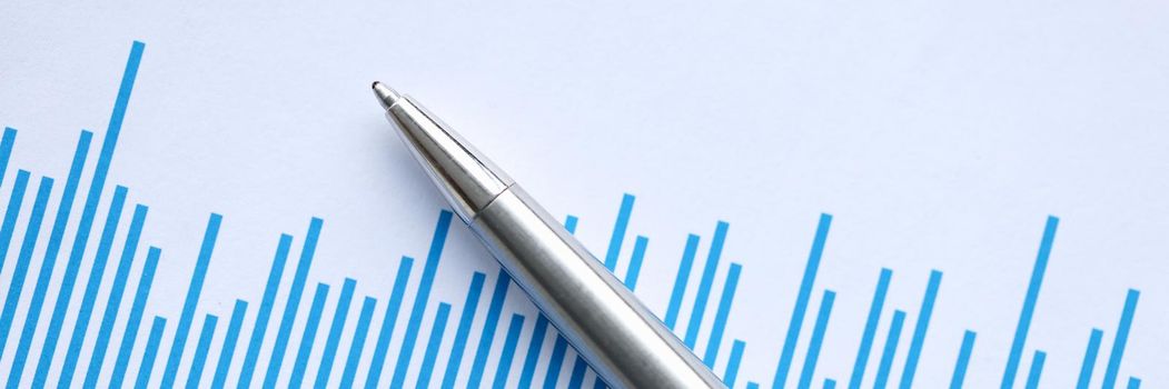 Ballpoint pen lying on document with graph closeup. Profit growth in business concept