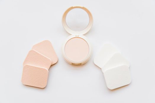 face cosmetic compact makeup powder with sponges white background