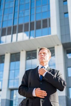 professional mature man standing front building