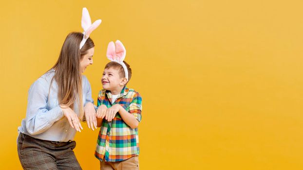 mother son imitating rabbit with copy space