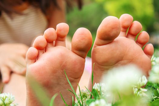 Baby feet on the green grass. Selective focus. nature.