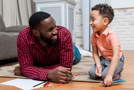 black father son with pencils floor