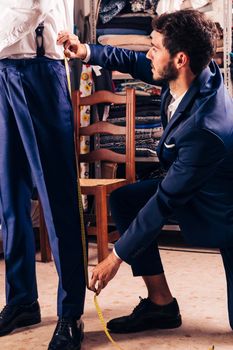 fashion designer taking measurement male customer s pant shop