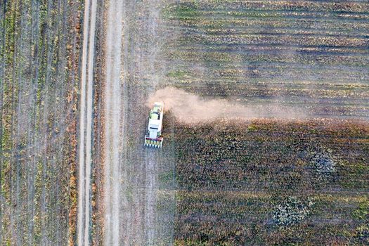 Harvester machine working in the field. Combine harvester agriculture machine harvesting sunflower field. Agriculture. Aerial view. From above.