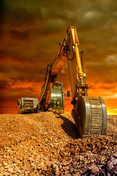 Stunning view at crawler excavator during earthmoving works on construction site at sunset