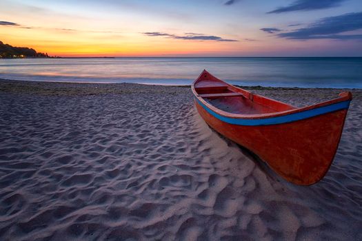 beauty morning with the lonely red boat on the sea beach 