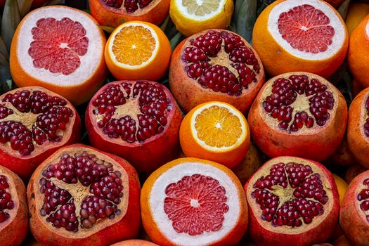 Many opened fruits at a market in Istanbul, Turkey during sunny day. Nice natural background with pomegranates, oranges and grape-fruits.