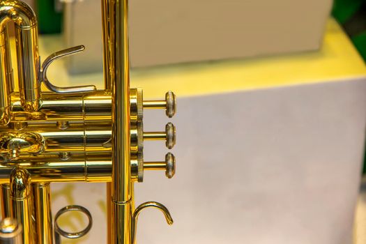 A part of the stunning golden trumpet with brass details. Close up of trumpet finger buttons valves