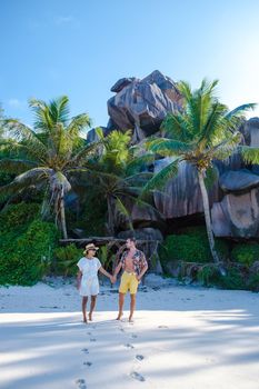 Anse Cocos beach, La Digue Island, Seyshelles, Drone aerial view of La Digue Seychelles bird eye view.of tropical Island, couple men and woman walking at the beach during sunset at a luxury vacation
