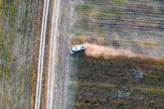 Harvester machine working in the field. Combine harvester agriculture machine harvesting sunflower field. Agriculture. Aerial view. From above.