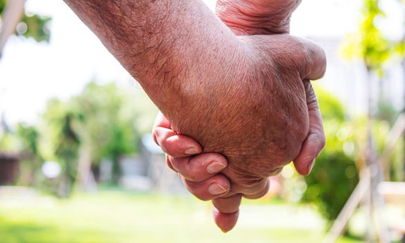 old man holding child's hands. selective focus people