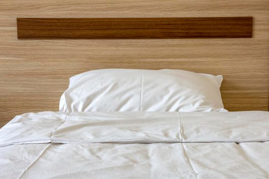 Soft pillow on a comfortable wood bed. Bedroom Interior. Front view