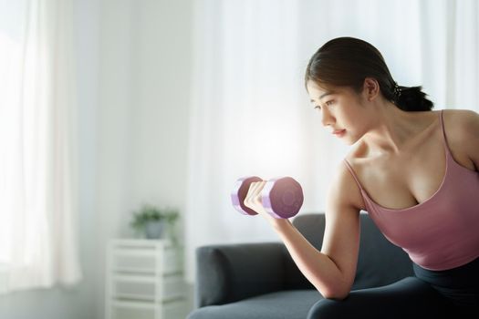 stress relief, , breathing exercises, meditation, portrait of Asian healthy woman lifting weights to strengthen her muscles after work