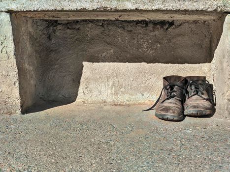 old work boots laid on the ground after a day's work