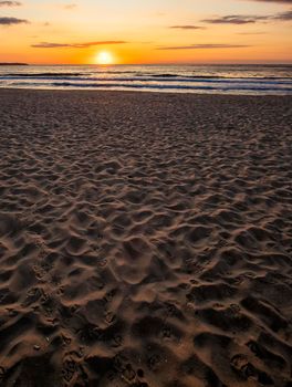 Beautiful sea sunset or sunrise over the sea from the sand. Vertical view