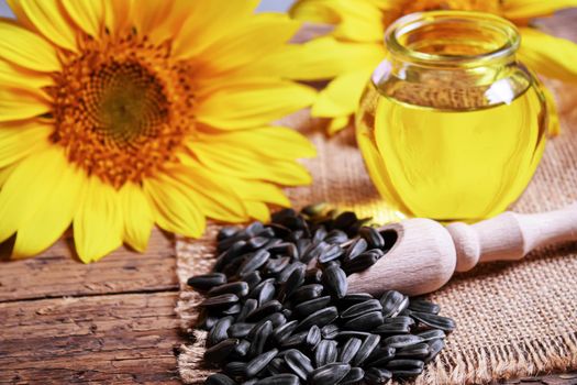 Sunflower seeds and oil bottle on old wooden background. Selective focus.nature