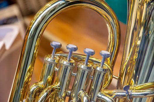 A part of the classical wind instrument with brass details. Close up of trumpet finger buttons valves
